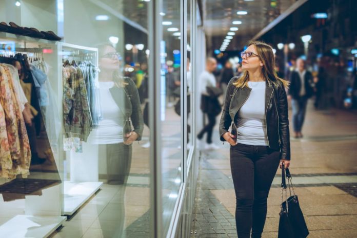 Frau vor Schaufenster eines Kleidergeschäfts