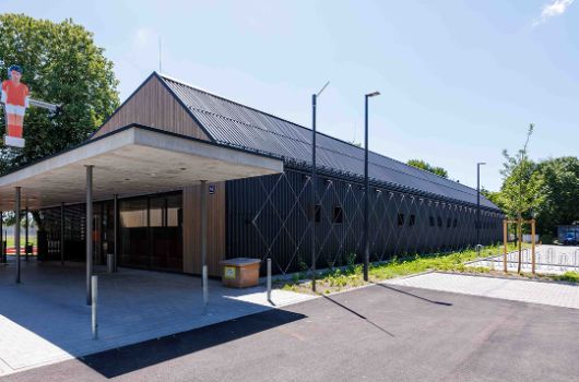 Gebäude der Bezirkssportanlage  mit Vordach und Kickerfigur