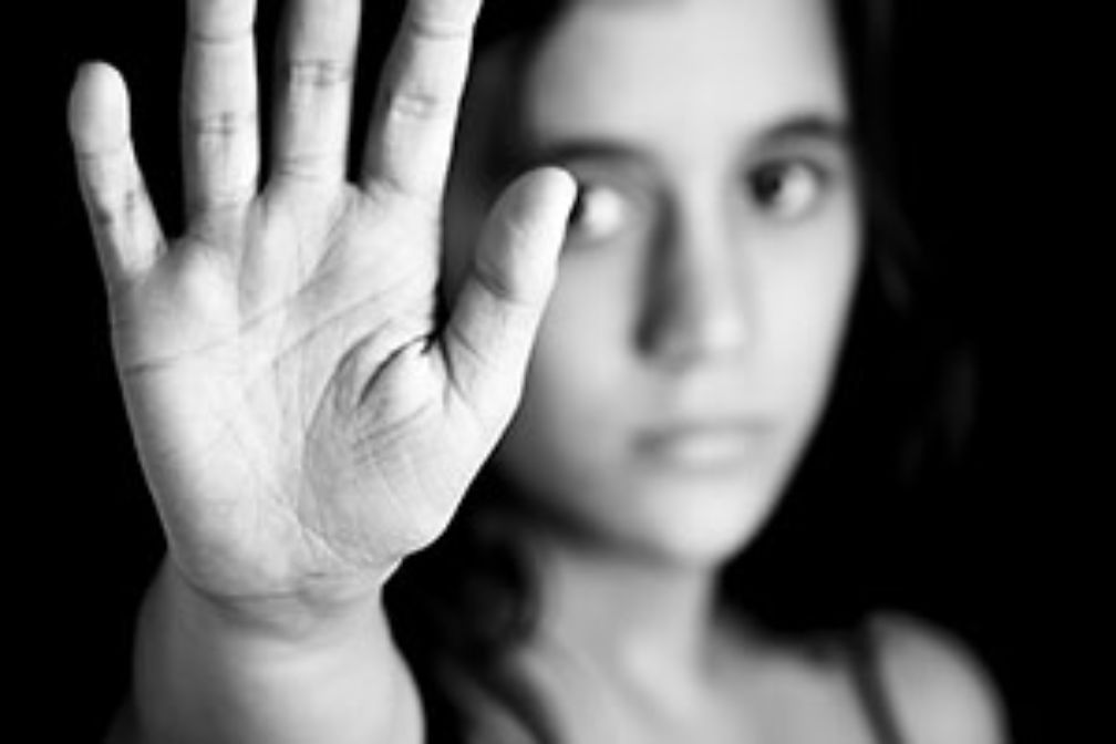 Junge Frau hebt Hand zum Schutz vor Gewalt