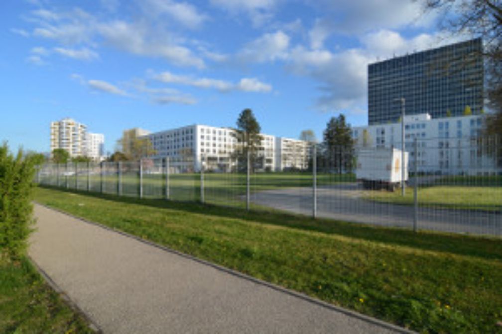 Die Bestandsgebäude auf dem ehemaligen Siemens-Gebäude. Das Gelände wird von einem Zaun eingefasst.