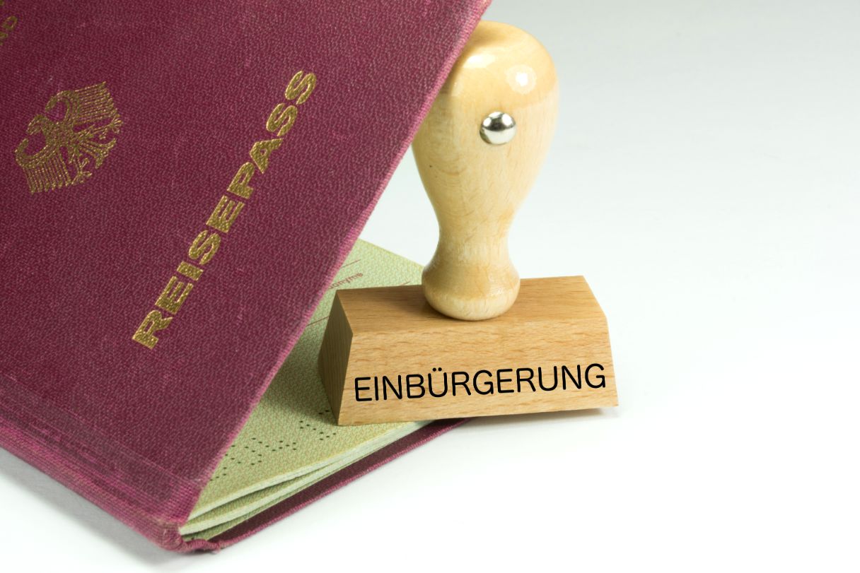 Aufgeschlagener deutscher Reisepass mit Stempel, darauf der Text Einbürgerungen