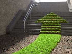 Treppe mit einem grünen Rasenstreifen mit Pfeilspitze, der eine graue Treppe hinauf führt 