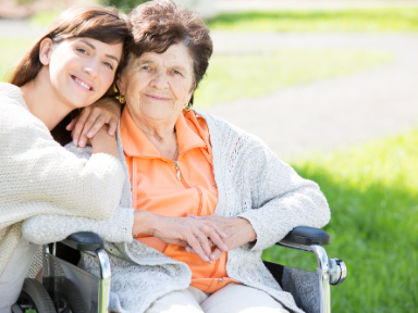 Junge Frau mit älterer Frau im Rollstuhl