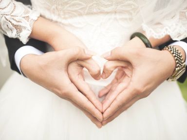Hochzeitspaar formt mit den Händen ein Herz