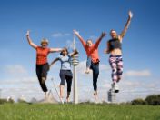 Vier Damen in Sportkleidung vor Olympiaturm