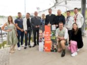 Auf dem Bild sind Oberbürgermeister Dieter Reiter, Ministerpräsident Dr. Markus Söder und Innenminister Joachim Herrmann zu sehen. Außerdem sind mehrere Sportler*innen auf dem Bild. Sie lächeln in die Kamera. In der Mitte wird das Themenmotiv 