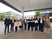 Würdenträger*innen überreichen Einweihungstafel und Einweihungsschlüssel an die Campusfamilien.