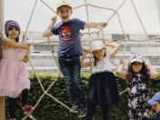 Vier Kinder im Kindergartenalter hängen an einem Kletterseil. 