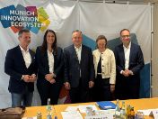 Podiumsteilnehmer vor Banner Munich Innovation Ecosystem - Innovationsagenda 2030