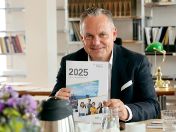 Wirtschaftsreferent Scharpf am Schreibtisch zeigt Jahreswirtschaftsbericht München 2025