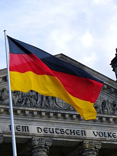 Wehende Deutschand Flagge vor dem Reichstagsgebäude in Berlin. 