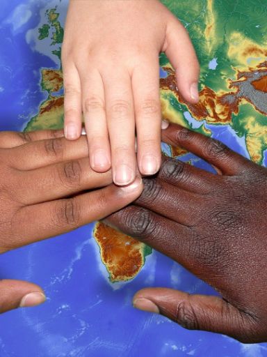 Hände verschiedener Hautfarben liegen aufeinander auf einer Karte.