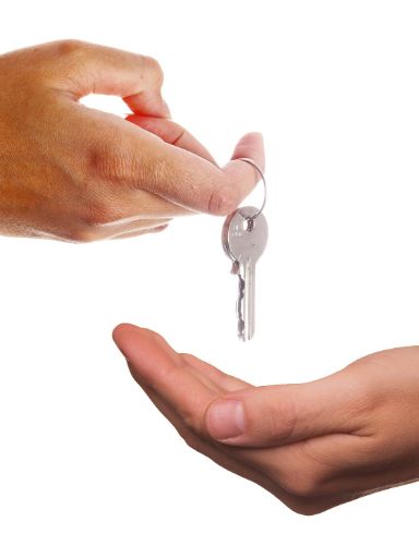 Ein Schlüssel wird von einer Person an eine ander Übergeben. 