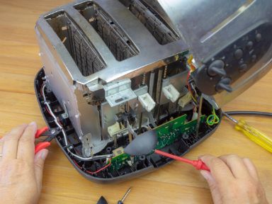 Mann repariert einen Toaster