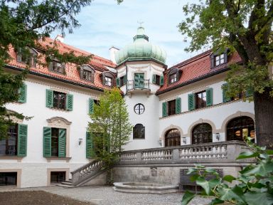 Blick auf die Terrasse mit Brunnen und Turm im Hintergrund.