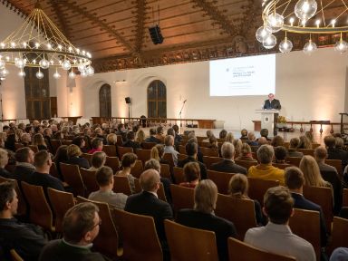 Publikum im Alten Rathaussaal zum Abschluss ÖKOPROFIT 21/22, Wirtschaftsreferent Clemens Baumgärtner spricht auf der Bühne
