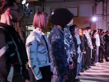 Reihe Models mit bunten Patch-Outfits auf einer Bühne 