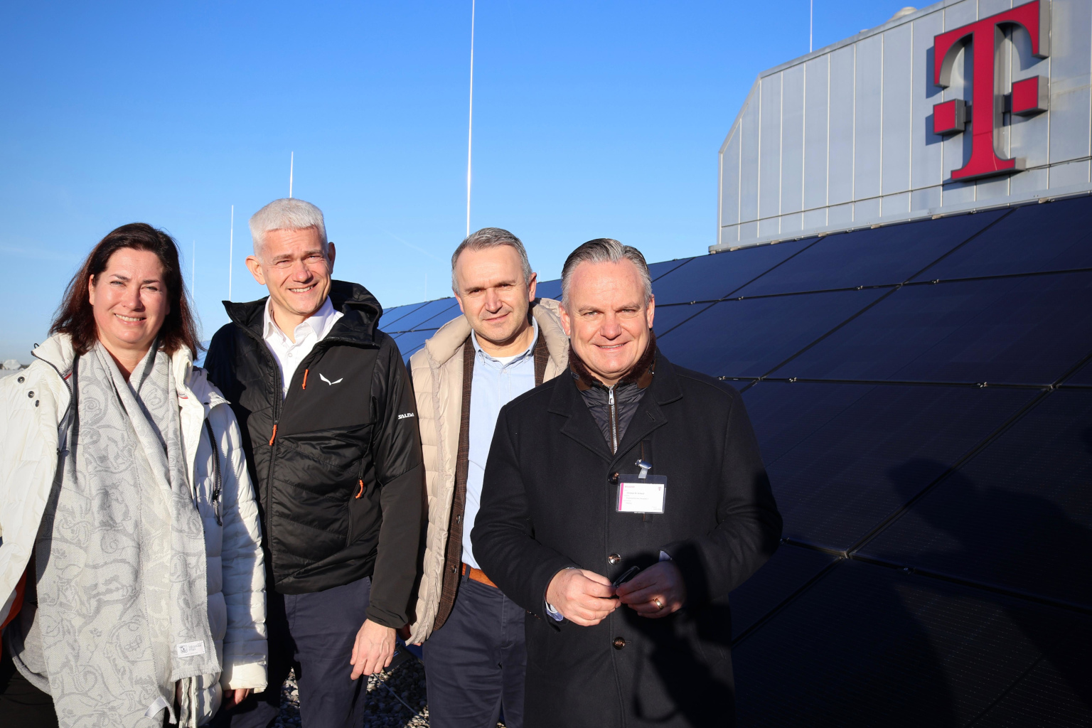 Telekom-MItarbeitende und Wirtschaftsreferent C. Baumgärtner vor PV-Anlage der Telekom am Marsplatz