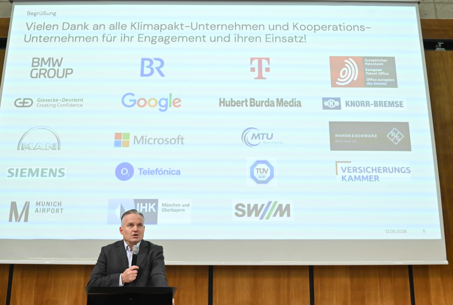 Referent Scharpf dankte den Unternehmen, hier als Logos im Hintergrund